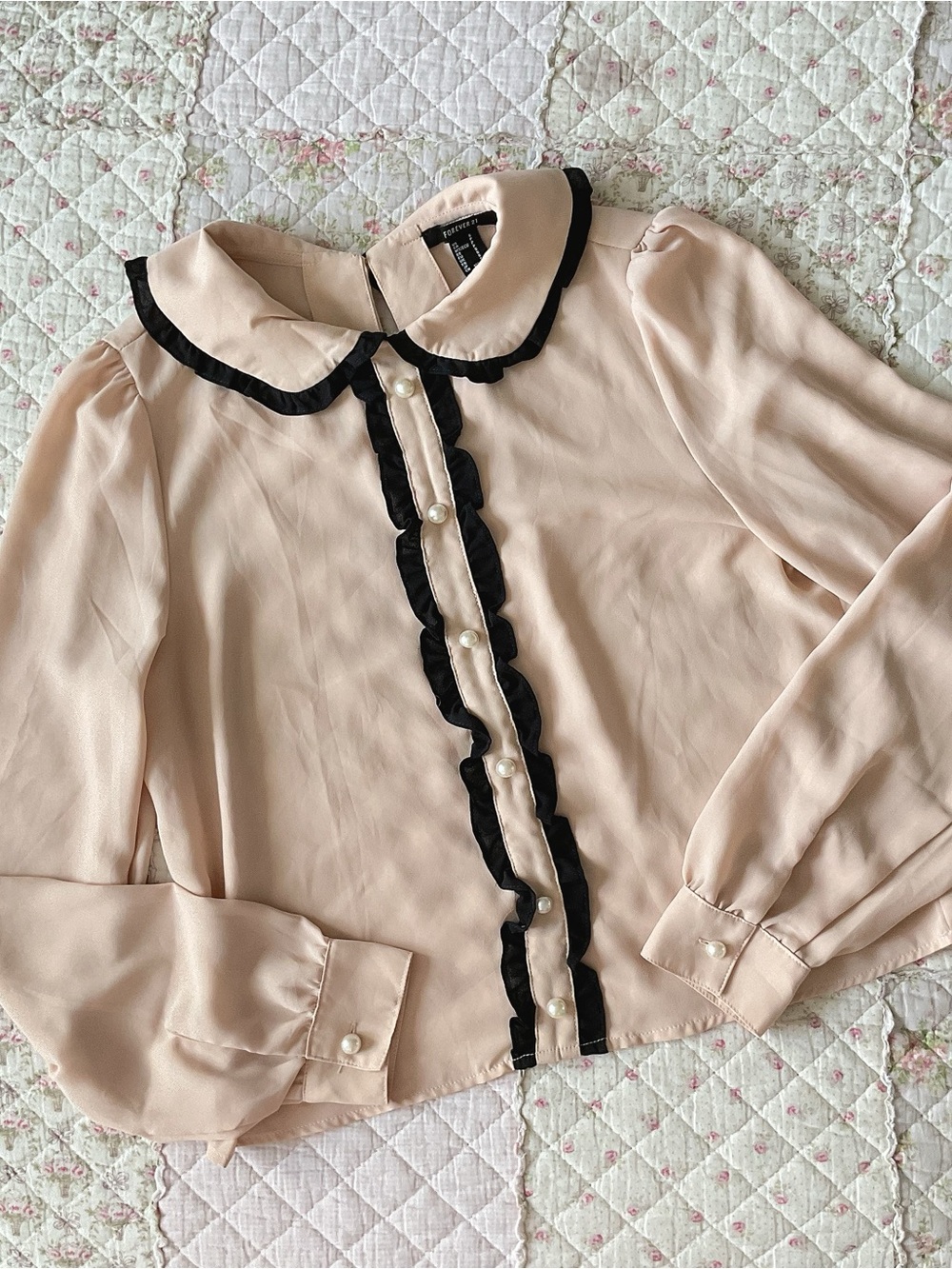 Peter pan collar blouse with black scalloped trim and pearl buttons
